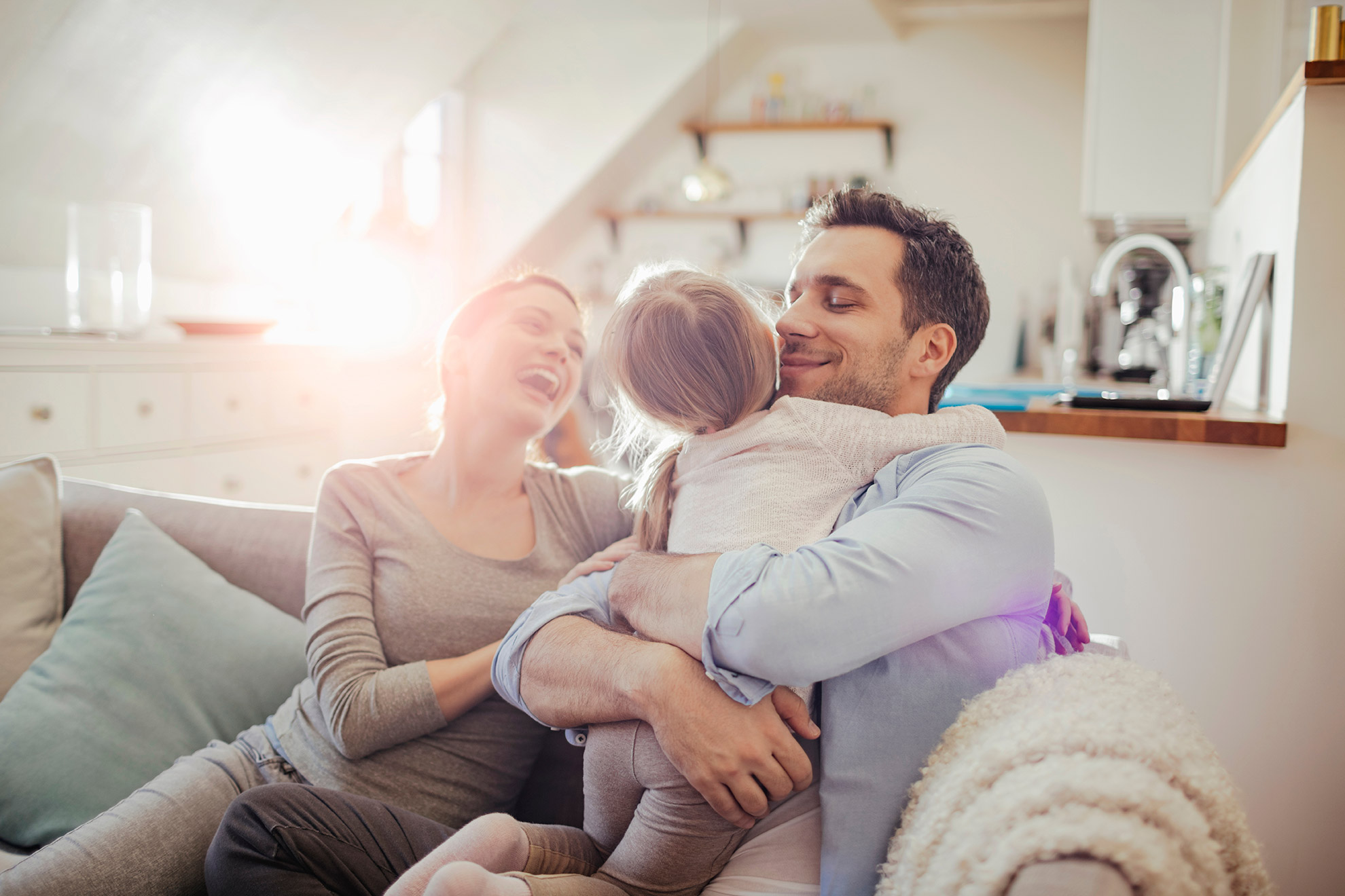 Mum, dad and kid on a sofa.